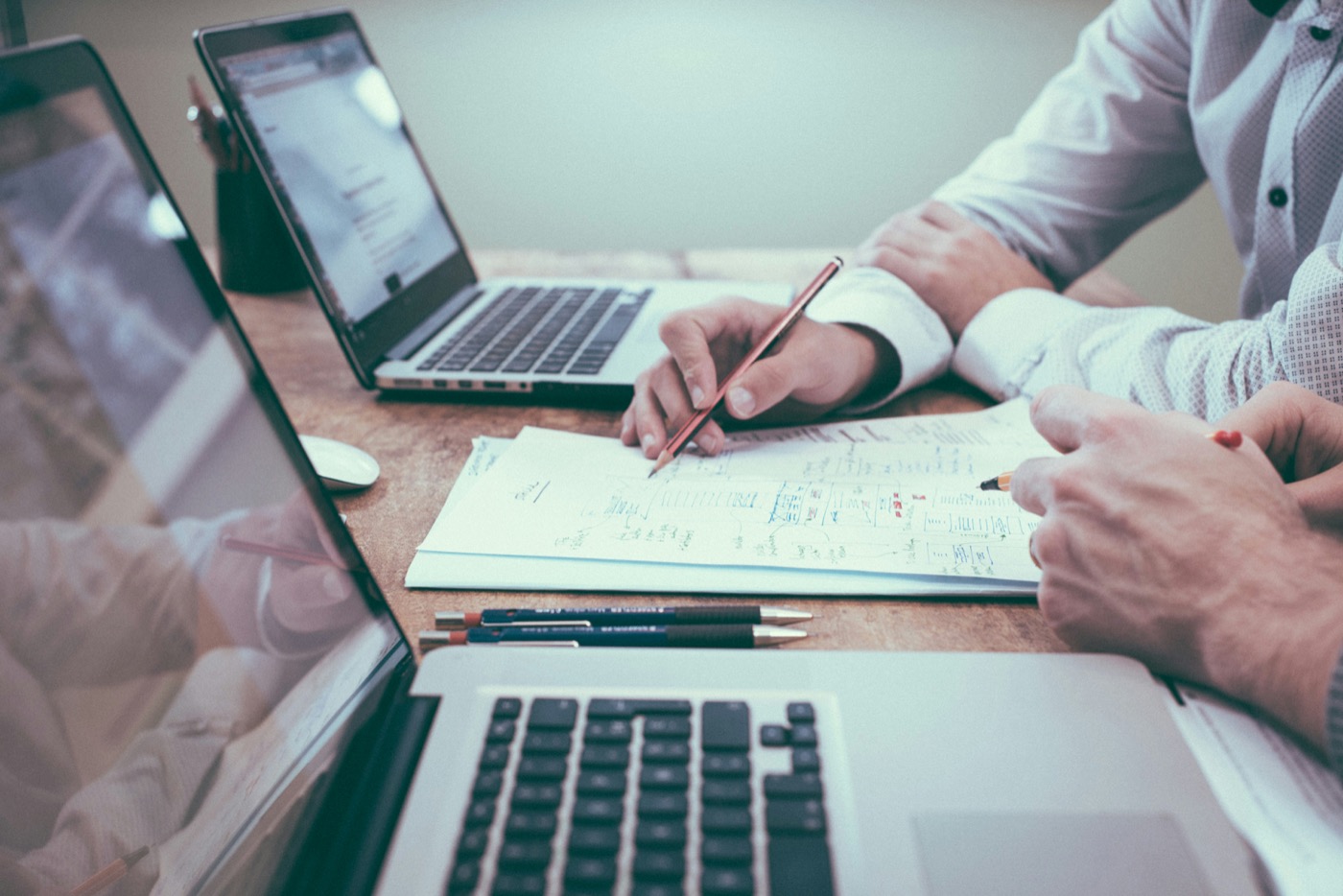 Gemeinsame Finanzplanung am Tisch mit Laptops und Notizen